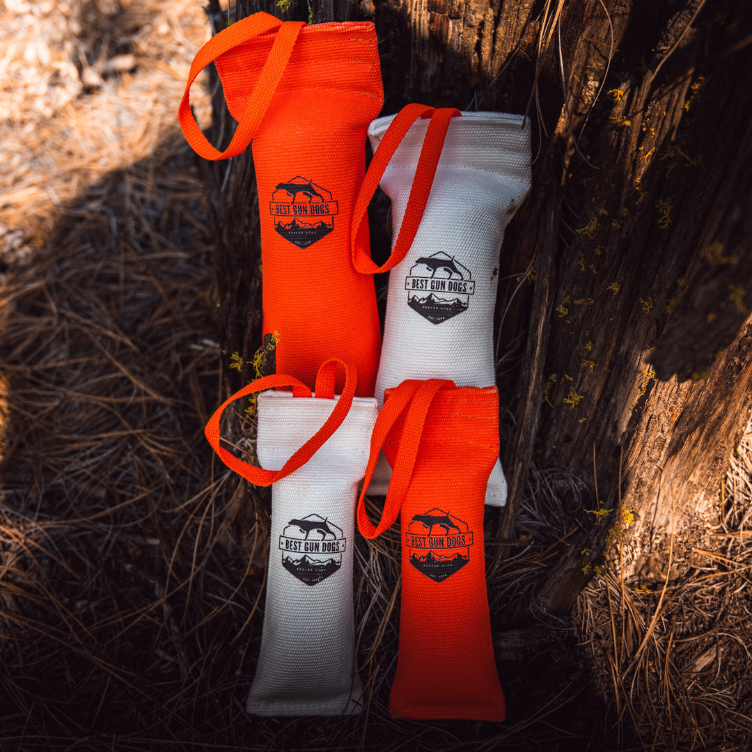 Large - Best Gun Dogs Firehose Training Dummy in orange and white, made with durable poly firehose material outdoors.